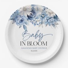 a paper plate with blue flowers and the words baby in bloom on it, against a white background