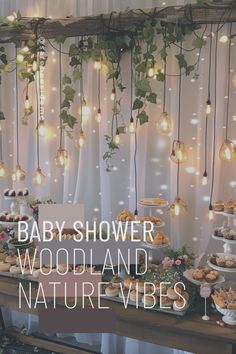 baby shower woodland nature vibes with lights hanging from the ceiling and greenery on the wall