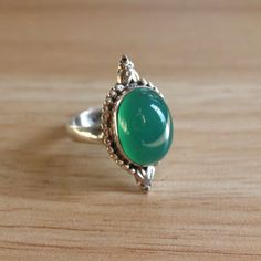 This size 9.25 beautiful green glass vintage ring is a casual but beautiful piece!  Sterling silver is hypoallergenic and safe for those with sensitive skin.  DIMENSIONS:  Band width: 3.5 millimeters Glass dimensions: 15.5 millimeters x 12.0 millimeters Weight: 6.5 grams Please note that vintage jewelry is pre-loved and might have minor imperfections as seen in the listing images. Classic Green Crystal Ring In Sterling Silver, Classic Adjustable Green Emerald Ring, Vintage Green Crystal Ring For Anniversary, Classic Green Cabochon Ring, Adjustable Vintage Green Rings, Green Vintage Adjustable Rings, Green Oval Crystal Ring In Sterling Silver, Oval Green Crystal Sterling Silver Ring, Green Oval Cabochon Ring For Gift