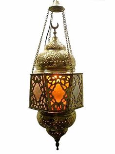 an ornate hanging lantern is lit up against a white background