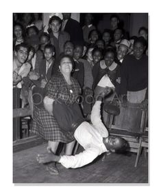 an old black and white photo of a person falling on the floor in front of a crowd