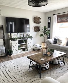 a living room filled with furniture and a flat screen tv mounted on the wall above a wooden coffee table