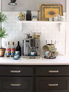 the kitchen counter is full of bottles and other items, including an espresso machine