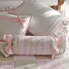 a bed with pink and white comforters and pillows