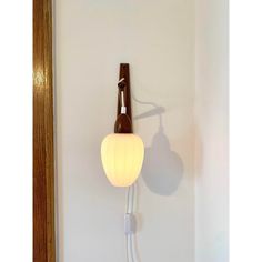 a wall mounted light with a bottle on the top and a cord attached to it