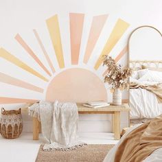 a bed room with a neatly made bed and a large sun mural on the wall