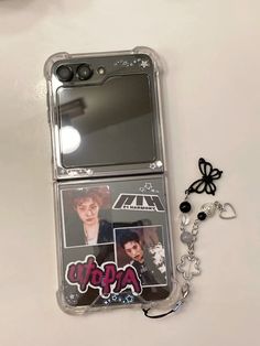 a cell phone case with some stickers on it next to a keychain