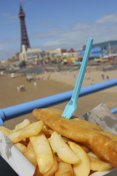 french fries in a basket on the beach with a view of the eiffel tower