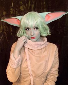 a woman with green hair and bunny ears on her head is posing for the camera