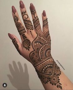 a woman's hand with henna tattoos on it