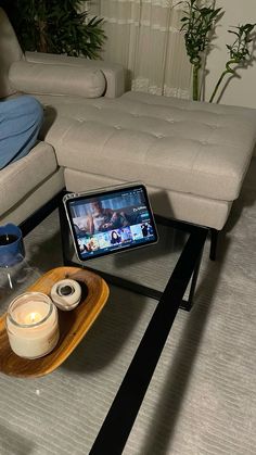 a living room with a couch, coffee table and cell phone on the tray next to it