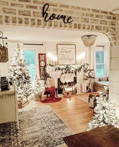 a living room decorated for christmas with white and red decorations on the fireplace mantles