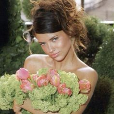 a beautiful young woman holding a bouquet of flowers