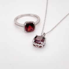 This deep red cushion-cut garnet is breathtaking and set beautifully within a diamond halo. This necklace was designed with a matching ring as shown in the pictures. These two make a stunning set that is the perfect addition to any jewelry collection. The necklace looks great on any woman as it will match their lipstick and lips! The details for this beautiful necklace are listed below:Metal Quality: 14K White GoldPendant Style: Garnet Diamond HaloDiamond Number: 20Diamond Shape: Round Brilliant Diamond Cut Ruby Jewelry As Gift, Diamond-cut Ruby Jewelry As Gift, Elegant Round Cut Garnet Jewelry, Diamond-cut Ruby Jewelry For Gifts, Formal Ruby Necklace With Halo Setting, Fine Jewelry Ruby With Diamond Cut, Dazzling Ruby Jewelry For Gifts, Ruby Halo Jewelry In White Gold, White Gold Ruby Halo Jewelry