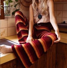 a woman sitting on top of a counter next to a potted plant