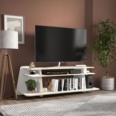 a living room with a large flat screen tv on top of a white entertainment center