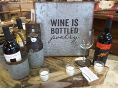 wine bottles and glasses on a table with a sign that says wine is bottled poetry