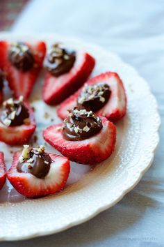 strawberries are arranged on a plate with chocolate sauce