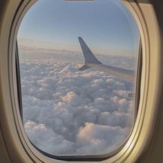 an airplane window looking out at the clouds