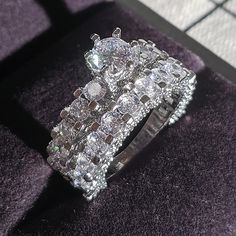 a diamond ring sitting on top of a purple velvet covered floor next to a window