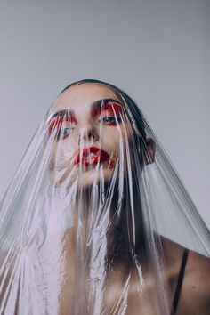 a woman with red makeup and plastic covering her face