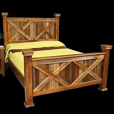 a wooden bed frame with two night stands next to it and a plant in the corner