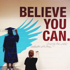 a woman is painting a mural on the side of a building that says, believe you can