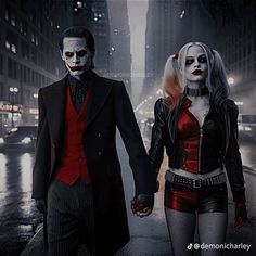 two people dressed up as the joker and harley in a city at night with lights on