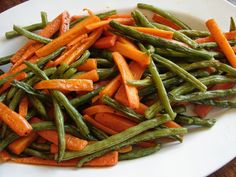 a white plate topped with green beans and carrots