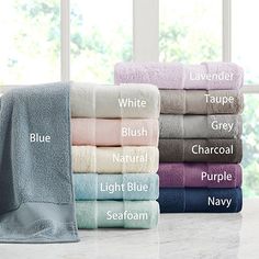 towels stacked on top of each other in front of a window with the names of different colors