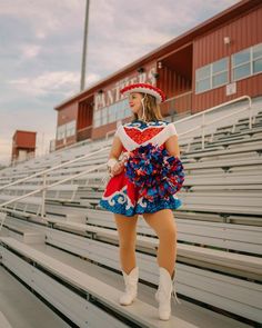 a woman in a cheerleader outfit standing on bleachers