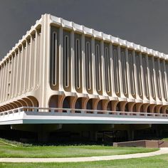 a large building that is in the middle of some grass and has arches on it