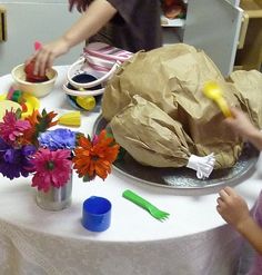 two children are playing with paper flowers on the table