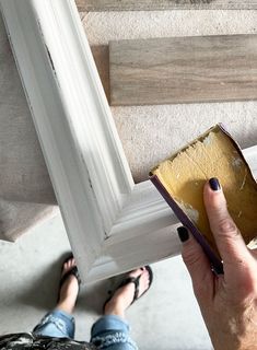 a person is painting the bottom part of a white frame with yellow and brown paint