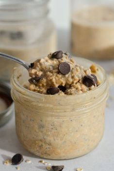 a jar filled with oatmeal and chocolate chips on top of a table