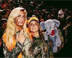 two women standing next to each other in front of an audience with stuffed animals on their shoulders