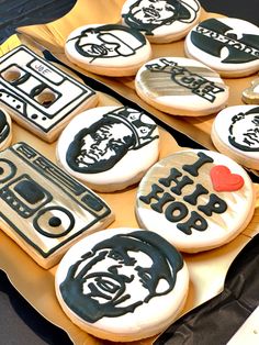 decorated cookies with black and white frosting are on a yellow tray in the shape of an old school radio