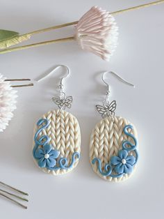 the earrings are decorated with blue and white flowers