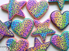 decorated cookies in the shape of hearts and stars on a white table with leopard print