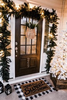 the front door is decorated for christmas with greenery