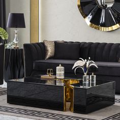 a living room with black couches, gold accents and a large mirror on the wall