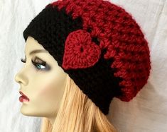 a mannequin head wearing a red and black crocheted hat with hearts