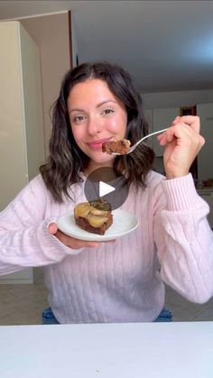 a woman holding a plate with some food on it