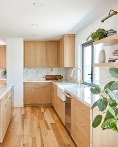 a kitchen with wooden cabinets and white marble counter tops, along with hardwood flooring