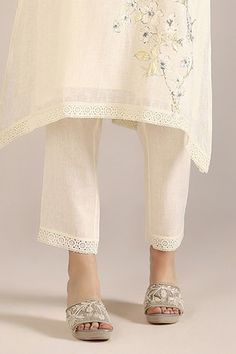 Off-white kurta with camelia flower print and crochet lace embroidered cutwork border. Paired with pant. - Aza Fashions Beige Floral Embroidered Pants For Spring, White Feminine Sets For Spring, Cotton Bottoms With Chikankari Embroidery For Spring, Spring Cotton Pants With Chikankari Embroidery, Spring Cotton Bottoms With Chikankari Embroidery, White Lace Work Sets For Summer, White Lace Work Summer Set, Spring Cotton Bottoms With Lace Work, White Lace Summer Set