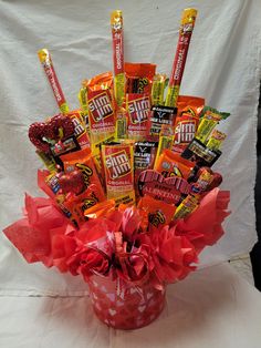 a red vase filled with candy and candies