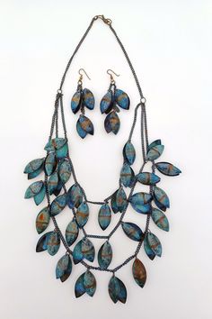 Vintage Boho Blue Patinated Metal Necklace and Earring Set  This listing features a unique Vintage Boho 3-tier necklace and dangle earring set made of blue-patinated chained metal, likely copper or brass, with almond-shaped drops. This set is in good, used, vintage condition with no breaks. It is a standout Boho piece from the 1960s-1970s.  Dimensions: The necklace is about 22" long. The earrings are about 3 1/4" long. Blue Oxidized Dangle Jewelry, Blue Teardrop Patina Jewelry, Blue Teardrop Jewelry With Patina, Blue Soldered Dangle Jewelry, Blue Metal Jewelry With Patina, Unique Blue Necklace With Patina, Metal Teardrop Jewelry With Patina, Teardrop Metal Jewelry With Patina, Tiered Necklace