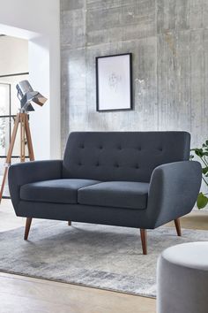 a gray couch sitting on top of a rug in a living room