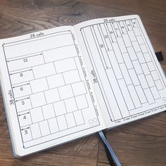 an open planner sitting on top of a wooden table next to a pair of scissors