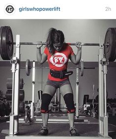 a woman is squatting on a bench with barbells in front of her